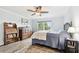 Bright bedroom features hardwood floors, ceiling fan, a large window, and a dresser at 701 Poinsettia Rd # 322, Belleair, FL 33756