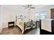 Cozy bedroom with hardwood floors, a ceiling fan, a large window, and a comfortable bed at 701 Poinsettia Rd # 322, Belleair, FL 33756