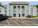 Light blue condo building featuring covered parking and landscaping at 701 Poinsettia Rd # 322, Belleair, FL 33756