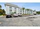 Exterior view of the condo building showcasing the parking lot and well-maintained landscaping at 701 Poinsettia Rd # 322, Belleair, FL 33756