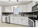 Modern kitchen with white cabinets, tile backsplash, and stainless steel appliances at 701 Poinsettia Rd # 322, Belleair, FL 33756