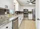 Updated kitchen with stainless appliances, stone countertops, and a neutral tile floor at 701 Poinsettia Rd # 322, Belleair, FL 33756
