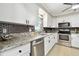 Well-lit kitchen features stainless appliances, white cabinets and stone countertops and backsplash at 701 Poinsettia Rd # 322, Belleair, FL 33756
