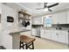 Bright kitchen featuring stainless appliances, stone countertops, and an open shelf with hanging pots at 701 Poinsettia Rd # 322, Belleair, FL 33756