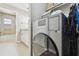 Laundry room with a modern washer/dryer, connecting to bathroom with stylish vanity at 701 Poinsettia Rd # 322, Belleair, FL 33756