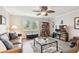 Inviting living room with wood flooring, ceiling fan, bookshelf and glass top coffee table at 701 Poinsettia Rd # 322, Belleair, FL 33756