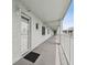 Outdoor walkway with light blue walls, white railing and a black doormat at 701 Poinsettia Rd # 322, Belleair, FL 33756