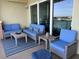 Relaxing balcony with blue patio furniture, a striped rug, and sliding glass doors with an ocean view at 706 Bayway Blvd # 502, Clearwater Beach, FL 33767