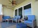 Inviting balcony features a ceiling fan, comfortable seating, a striped rug, and picturesque views through sliding glass doors at 706 Bayway Blvd # 502, Clearwater Beach, FL 33767