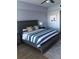 This primary bedroom features a wooden bed frame with stylish linens, decorative pillows, and an area rug at 706 Bayway Blvd # 502, Clearwater Beach, FL 33767
