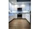 Well-lit kitchen with stainless steel appliances, contemporary cabinets, and stylish wood flooring at 706 Bayway Blvd # 502, Clearwater Beach, FL 33767