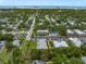 Aerial view of a condominium complex with mature trees, parking, and a glimpse of the water at 720 Lyndhurst St # 1101, Dunedin, FL 34698