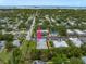Aerial view of a condominium complex with mature trees, parking, and a glimpse of the water at 720 Lyndhurst St # 1101, Dunedin, FL 34698