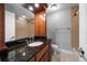 Bathroom with a shower and granite countertop sink with wood cabinet at 720 Lyndhurst St # 1101, Dunedin, FL 34698