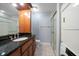 Bathroom with a stand up shower, granite countertop sink and wood cabinet at 720 Lyndhurst St # 1101, Dunedin, FL 34698