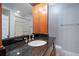 Bathroom with a stand up shower, granite countertop sink and wood cabinet at 720 Lyndhurst St # 1101, Dunedin, FL 34698