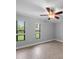 Neutral bedroom featuring large windows, tile floors, and a ceiling fan at 720 Lyndhurst St # 1101, Dunedin, FL 34698