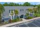 Exterior daytime shot of condo building, showing palm trees, a gray roof, and convenient parking at 720 Lyndhurst St # 1101, Dunedin, FL 34698