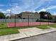 Community basketball court with a red surface, a chain-link fence, and a basketball hoop on each end at 7603 Wood Violet Dr, Gibsonton, FL 33534