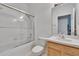 Bathroom with shower-tub combo and tile surround, plus single sink vanity and a framed mirror at 7603 Wood Violet Dr, Gibsonton, FL 33534