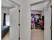 Hallway view into bedroom featuring white doors, and a view of the bed and the computer desk at 7603 Wood Violet Dr, Gibsonton, FL 33534