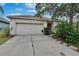 Inviting single-story home featuring a two-car garage and a well-manicured front yard at 7603 Wood Violet Dr, Gibsonton, FL 33534