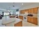 Open kitchen has an island with sink, oven, microwave, and wooden cabinets with view to the outside at 7603 Wood Violet Dr, Gibsonton, FL 33534