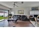 Living room with sliding glass door, ceiling fan, and plush leather furniture at 7603 Wood Violet Dr, Gibsonton, FL 33534