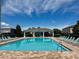 Community pool with a covered seating area and plenty of lounge chairs for relaxing by the water at 7603 Wood Violet Dr, Gibsonton, FL 33534