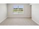 An airy bedroom featuring neutral walls, plush carpet, and a large window with picturesque views at 7678 Deer Valley Circle, Tampa, FL 33635