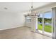Open dining area with sliding glass doors offering pond views and modern chandelier at 7678 Deer Valley Circle, Tampa, FL 33635