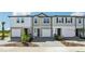 Modern townhomes exhibit varied exteriors with driveways, walkways, and landscaping at 7678 Deer Valley Circle, Tampa, FL 33635