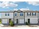 New townhomes show modern exteriors with driveways and landscaping under a sunny sky at 7678 Deer Valley Circle, Tampa, FL 33635