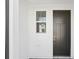 Modern home entryway with a dark front door, sidelight, and window at 7678 Deer Valley Circle, Tampa, FL 33635