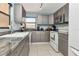 Well-lit kitchen with modern appliances, granite countertops, gray cabinets, and tile flooring at 7893 Sailboat Key S Blvd # 304, South Pasadena, FL 33707