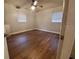 Comfortable bedroom featuring a ceiling fan, windows, and hard wood flooring at 820 Crenshaw Lake Rd, Lutz, FL 33548