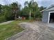 A wide concrete driveway beside a home with a garage and a shed in the grassy backyard at 820 Crenshaw Lake Rd, Lutz, FL 33548