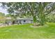 This home has lush green lawn and trees, and a view of the exterior showcasing its windows at 820 Crenshaw Lake Rd, Lutz, FL 33548