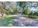 View of property with mature trees, open space, and driveway leading to a residence at 820 Crenshaw Lake Rd, Lutz, FL 33548