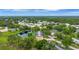 Lush, green aerial view of a residential area featuring homes, golf course, and pond at 900 Maclaren N Dr # D, Palm Harbor, FL 34684