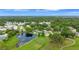 Expansive aerial view featuring a pond-side home, a golf course, and lush, green trees at 900 Maclaren N Dr # D, Palm Harbor, FL 34684