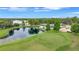 Picturesque aerial view of a pond-side home on a golf course, surrounded by lush greenery and trees at 900 Maclaren N Dr # D, Palm Harbor, FL 34684