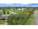 Aerial view showcasing the villa's location near a golf course, pond, and lush greenery at 900 Maclaren N Dr # D, Palm Harbor, FL 34684