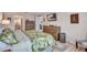 Comfortable bedroom with a tropical leafy comforter set, dresser, and mounted flatscreen TV at 900 Maclaren N Dr # D, Palm Harbor, FL 34684