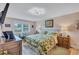 Relaxing bedroom features a leafy comforter set, decorative lamps, a window seat, and light colored walls at 900 Maclaren N Dr # D, Palm Harbor, FL 34684