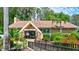 Exterior view of the community's well-maintained clubhouse with tropical landscaping at 900 Maclaren N Dr # D, Palm Harbor, FL 34684