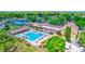 Aerial view of the large community pool surrounded by lush greenery, lounge chairs, and amenities at 900 Maclaren N Dr # D, Palm Harbor, FL 34684