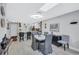 Open-concept dining room with light gray floors, view of kitchen, and modern ceiling fixture at 900 Maclaren N Dr # D, Palm Harbor, FL 34684
