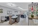 Open-concept dining room flowing into living area with bar, light gray floors, and modern ceiling fixture at 900 Maclaren N Dr # D, Palm Harbor, FL 34684