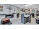 Open dining area featuring gray tile floors, modern lighting, a fireplace, and easy access to kitchen bar at 900 Maclaren N Dr # D, Palm Harbor, FL 34684